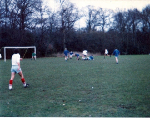 1st XI football pitch. 1975.<br>School 1st in blue vs Old Boys in white. Iain Fraser (OTT237 East) in the centre about to be penalised for knocking down school defence.